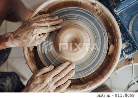 Flat Lay of Potter Master at Work in Clay Studio, Handmade Process of Creating Pot on a Pottery Wheel Flat Lay of Potter Master at Work in Clay Studio, Handmade Process of Creating Pot on a Pottery Wheel 91158069