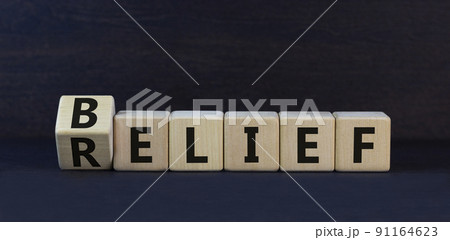 Belief or relief symbol. Turned wooden cubes and changed concept words relief to belief. Beautiful black table black background. Business, support and belief or relief concept. Copy space. Belief or relief symbol. Turned wooden cubes and changed concept words relief to belief. Beautiful black table black background. Business, support and belief or relief concept. Copy space. 91164623