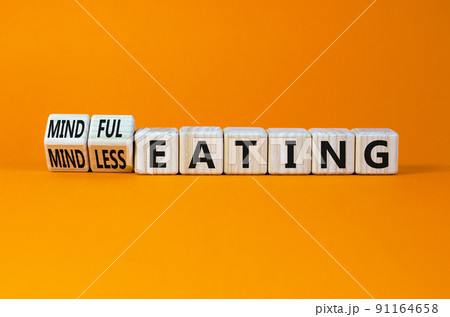 Mindful or mindless eating symbol. Turned wooden cubes and changed words mindless eating to mindful eating. Beautiful orange background, copy space. Medical and mindful or mindless eating concept. Mindful or mindless eating symbol. Turned wooden cubes and changed words mindless eating to mindful eating. Beautiful orange background, copy space. Medical and mindful or mindless eating concept. 91164658