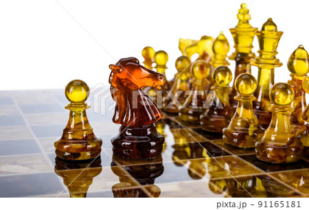 Natural amber different chess pieces figures standing on brown stone board. Close up game concept competition, Classic Gambit Tournament of confrontation. 91165181