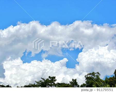 真夏の青空と白い雲と緑 91170551