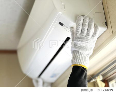 エアコンを取り付ける軍手をはめた手元 91176649