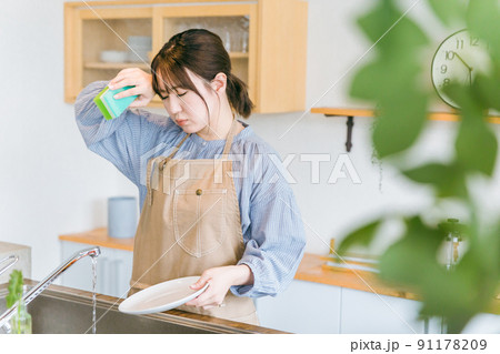 洗い物をする日本人女性（疲労） 91178209