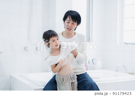 パパと一緒にお着替えをする小さな女の子 91179423