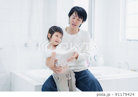 パパと一緒にお着替えをする小さな女の子 91179424