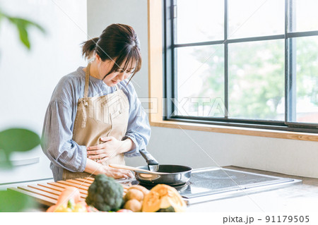 料理中に体調不良になる女性(お腹) 料理中に体調不良になる女性(お腹) 91179505