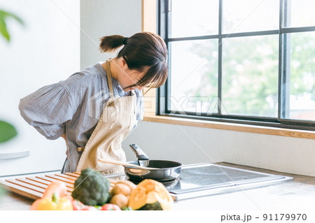 料理中に体調不良になる女性（腰） 91179970