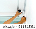 Technicians using a screwdriver to install  the CCTV cameras. 91181561