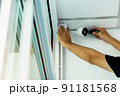 Technicians using a screwdriver to install  the CCTV cameras. 91181568