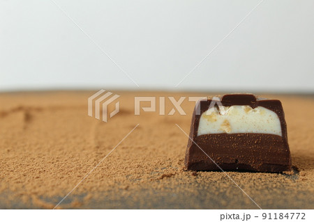 body chocolate candy with chocolate and white milk cream filling close-up against the cocoa background. A day of chocolate sweets without diet. handmade sweets 91184772