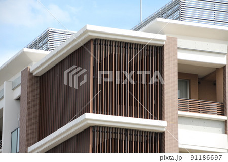 青空に映える2色使いの落ち着いた雰囲気のルーバーが美しいマンションの階段室の最上部 91186697