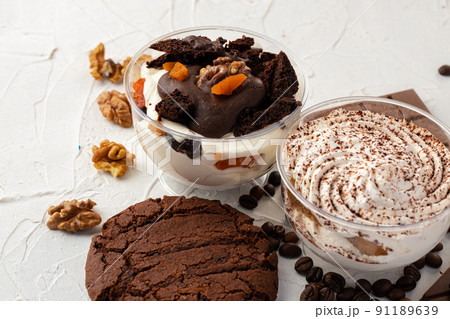 Cocoa mousse dessert in plastic transparent box on grey surface Cocoa mousse dessert in plastic transparent box on grey surface 91189639