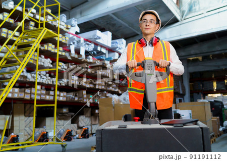 Warehouse worker operates a pallet loader 91191112