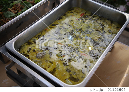 Thai food, Chicken Green Curry in buffet line. The container is a rectangular stainless steel tray. Selective focus. Thai food, Chicken Green Curry in buffet line. The container is a rectangular stainless steel tray. Selective focus. 91191605