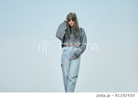 青空を背景に立つZ世代の女性 91192430