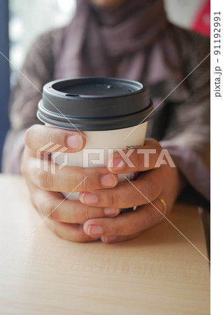 women holding a take away paper coffee cup  91192991
