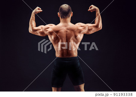 Sportsman of the year. Sportsman back view on black background. Strong sportsman flexing arm muscles triceps biceps. Sportsman or bodybuilder showing muscular back Sportsman of the year. Sportsman back view on black background. Strong sportsman flexing arm muscles triceps biceps. Sportsman or bodybuilder showing muscular back 91193338