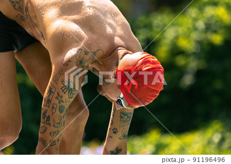 Closeup young handsome man, professional swimmer in goggles and swimming cap getting ready to swim, outdoors. Sport, power, energy, style, hobby concept. Closeup young handsome man, professional swimmer in goggles and swimming cap getting ready to swim, outdoors. Sport, power, energy, style, hobby concept. 91196496