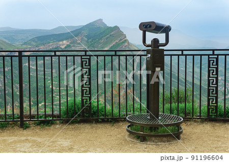 observation deck with a spotting scope over a mountain valley 91196604