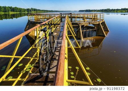Bicycle on the yellow spilway of river dam Bicycle on the yellow spilway of river dam 91198372
