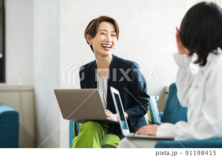コワーキングスペースで談笑するキャリアウーマン コワーキングスペースで談笑するキャリアウーマン 91198415