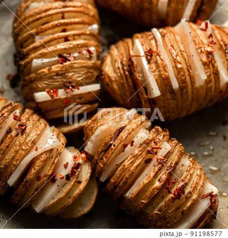 Hasselback Baked Potatoes with Fresh Herbs and pork fat, lard, tallow, garlic. National Ukrainian food. Top view. Hasselback Baked Potatoes with Fresh Herbs and pork fat, lard, tallow, garlic. National Ukrainian food. Top view. 91198577