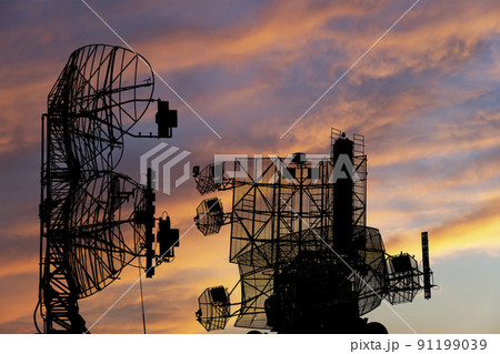 Air defense radars of military mobile anti aircraft systems, modern army industry on the background of the sunset orange sky, Russia 91199039