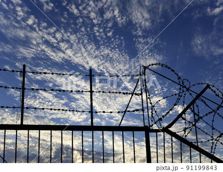 Contour of barbed wire on background beautiful clouds and sky Contour of barbed wire on background beautiful clouds and sky 91199843