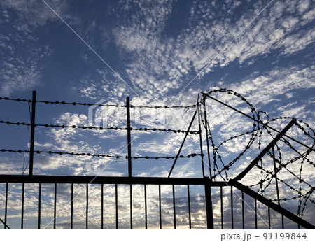 Contour of barbed wire on background beautiful clouds and sky Contour of barbed wire on background beautiful clouds and sky 91199844
