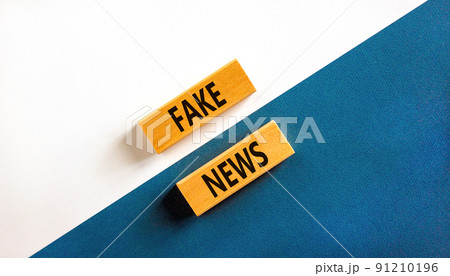Fake news symbol. Wooden blocks with concept words Fake news on beautiful white and blue background. Business media and fake news concept. Copy space. 91210196