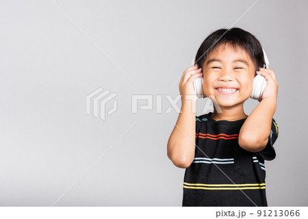 Little cute kid boy 5-6 years old listen music wear wireless headphones in studio shot isolated Little cute kid boy 5-6 years old listen music wear wireless headphones in studio shot isolated 91213066