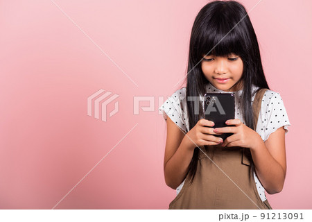 Asian kid 10 years enjoying using mobile phone for social network media 91213091