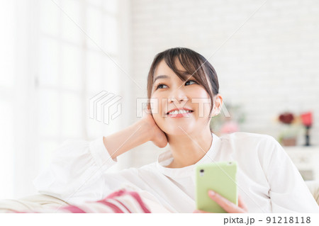部屋でスマホを見る女性 部屋でスマホを見る女性 91218118