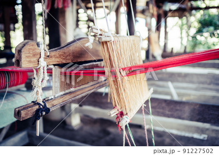 Thai and Asian Style Vintage textile thread wooden machine to make traditional clothing and fabric pattern weaving. Thai and Asian Style Vintage textile thread wooden machine to make traditional clothing and fabric pattern weaving. 91227502