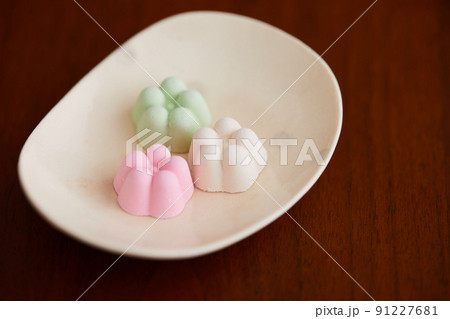 かわいらしいうつわに乗った花の形のカラフルな和三盆糖のお菓子 かわいらしいうつわに乗った花の形のカラフルな和三盆糖のお菓子 91227681