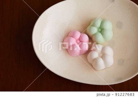 かわいらしいうつわに乗った花の形のカラフルな和三盆糖のお菓子 かわいらしいうつわに乗った花の形のカラフルな和三盆糖のお菓子 91227683