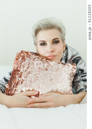 Smiling mature woman lying on bed at home 91228305