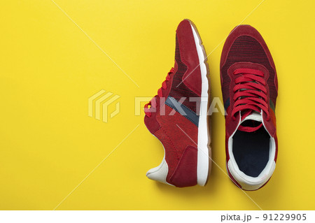 New unbranded running sneaker or trainer on yellow background. Men's sport footwear. 91229905