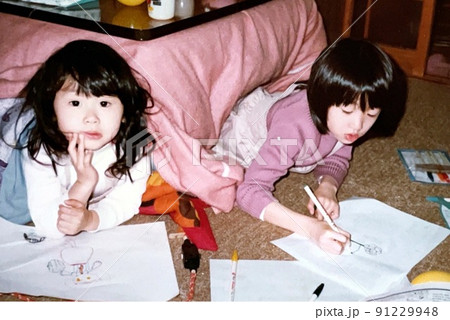昭和50年代 こたつでお絵かきをしている仲良し姉妹 91229948