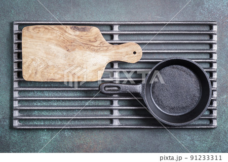 Cutting board and cast iron pan on grill grate Cutting board and cast iron pan on grill grate 91233311