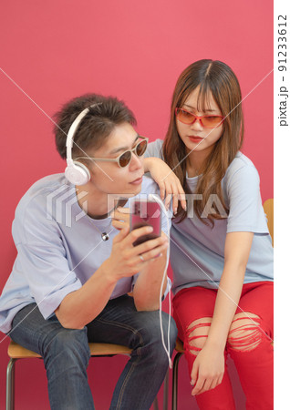 スマホの画面を見せる男性とそれを覗き込む女性のイメージ 91233612