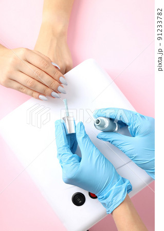 Nail care procedure on pink background, close up Nail care procedure on pink background, close up 91233782