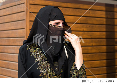 Muslim woman carefully looks into the distance on a bright sunny day 91237003
