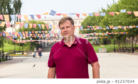 Blond man in the city square on a national holiday Blond man in the city square on a national holiday 91237034