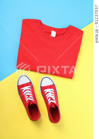 Blank t-shirt and sneakers on two tone background Blank t-shirt and sneakers on two tone background 91237037