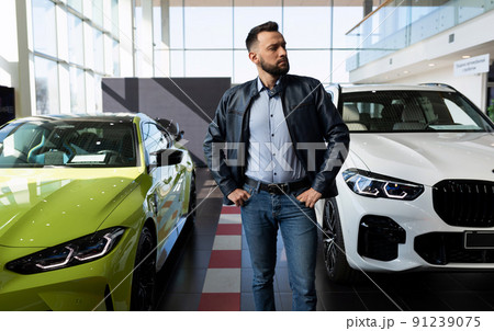 a man in a car dealership chooses a new car 91239075