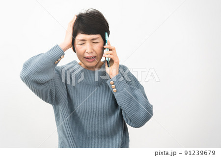 電話の内容でショックを受けるミドル女性 91239679