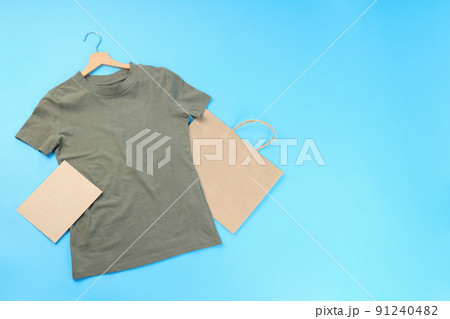 Blank t-shirt, bag and carton sheet on blue background Blank t-shirt, bag and carton sheet on blue background 91240482