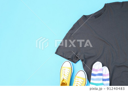 Blank t-shirt, sneakers and socks on blue background Blank t-shirt, sneakers and socks on blue background 91240483