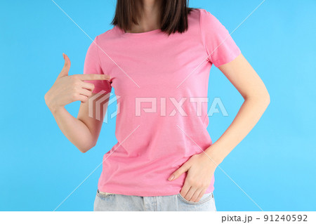 Attractive girl in pink t-shirt on blue background 91240592